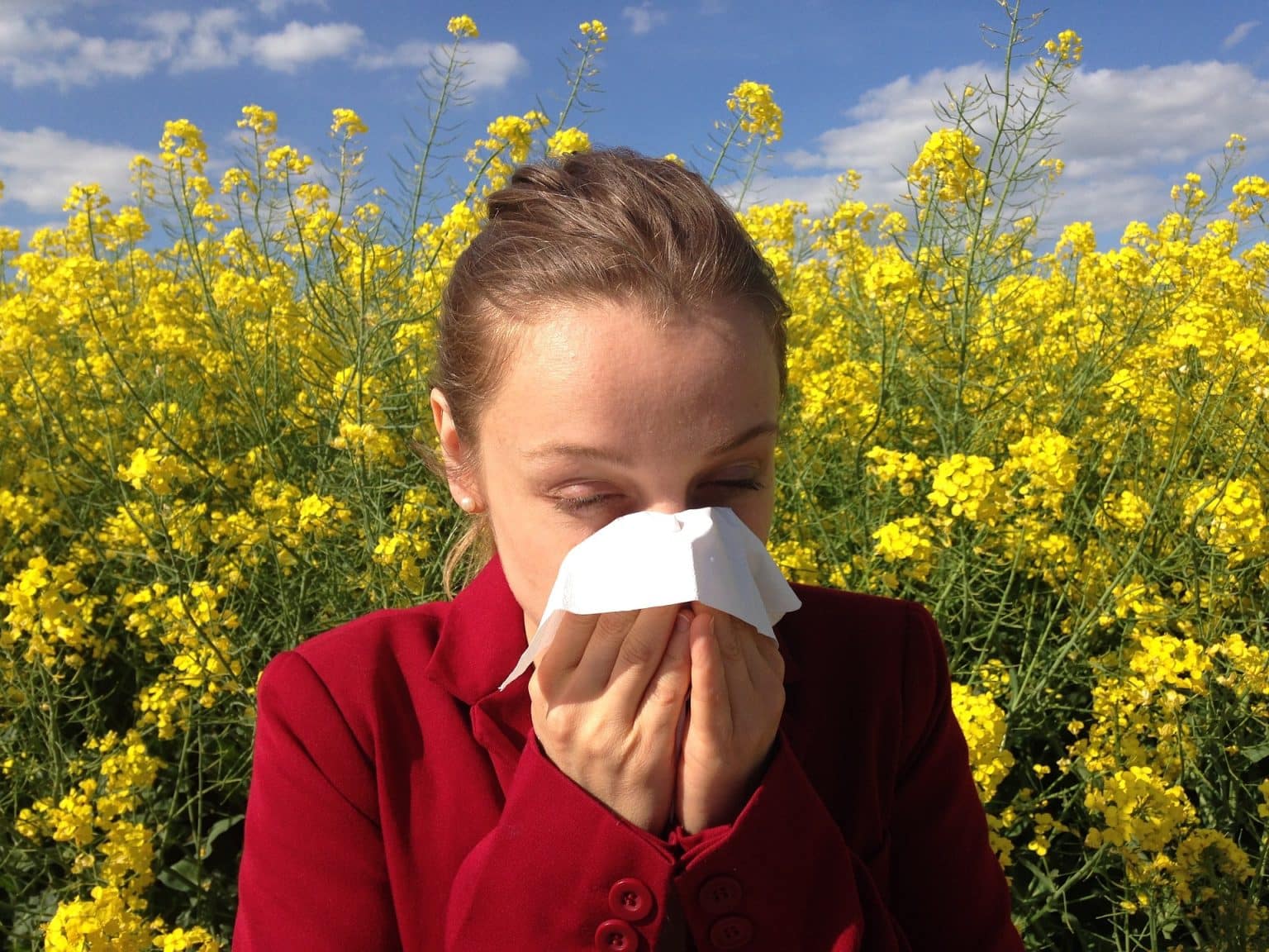 woman sneezing into tissue