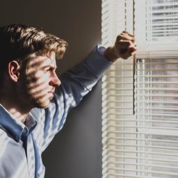 man looks out window