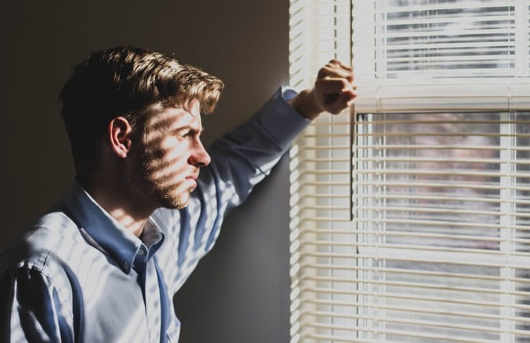 man looks out window