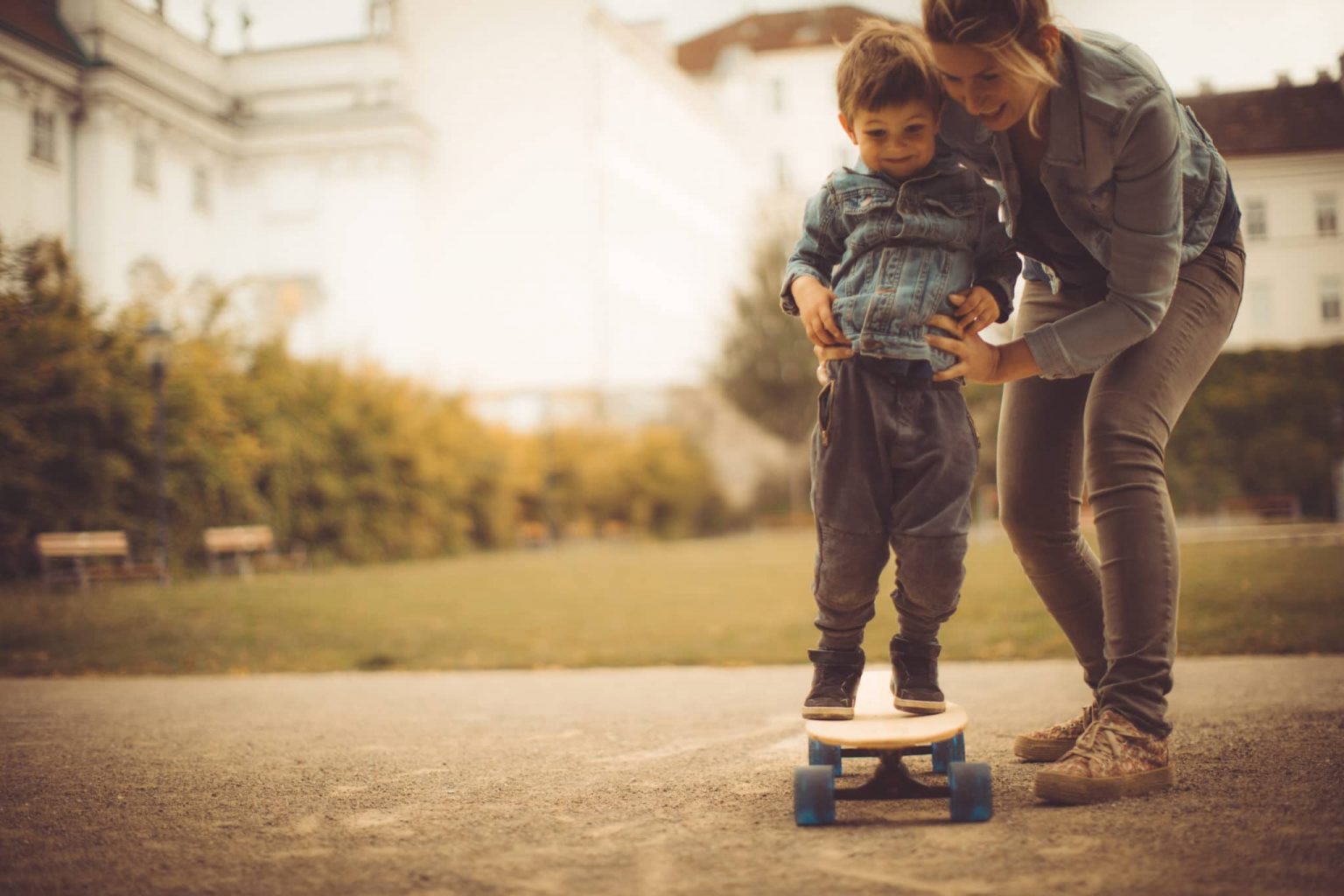Child on Skateboard Being Held By Mother Due to Recently Diagnosed Balance Disorder