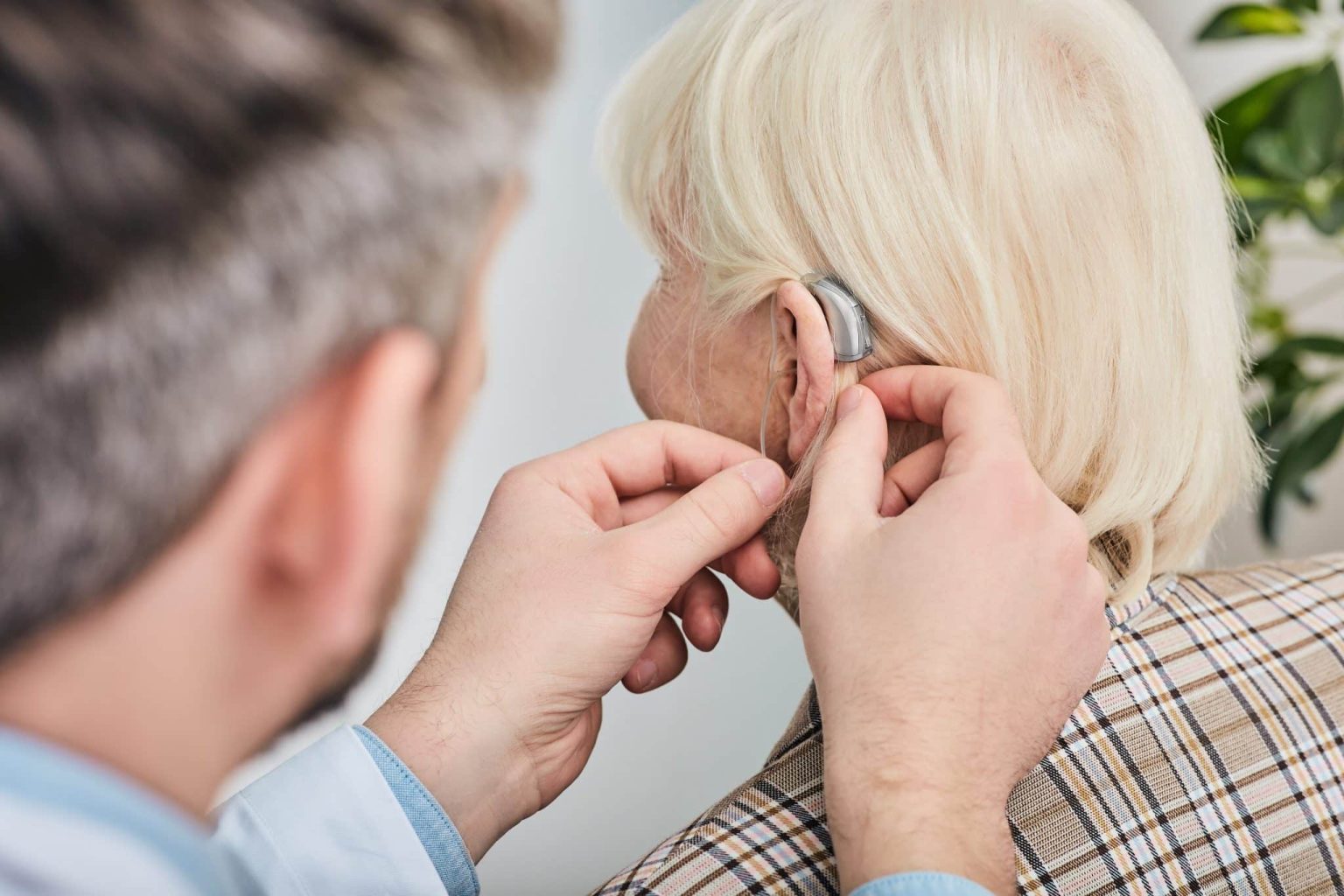Woman getting fitted for a hearing aid by hear audiologist.