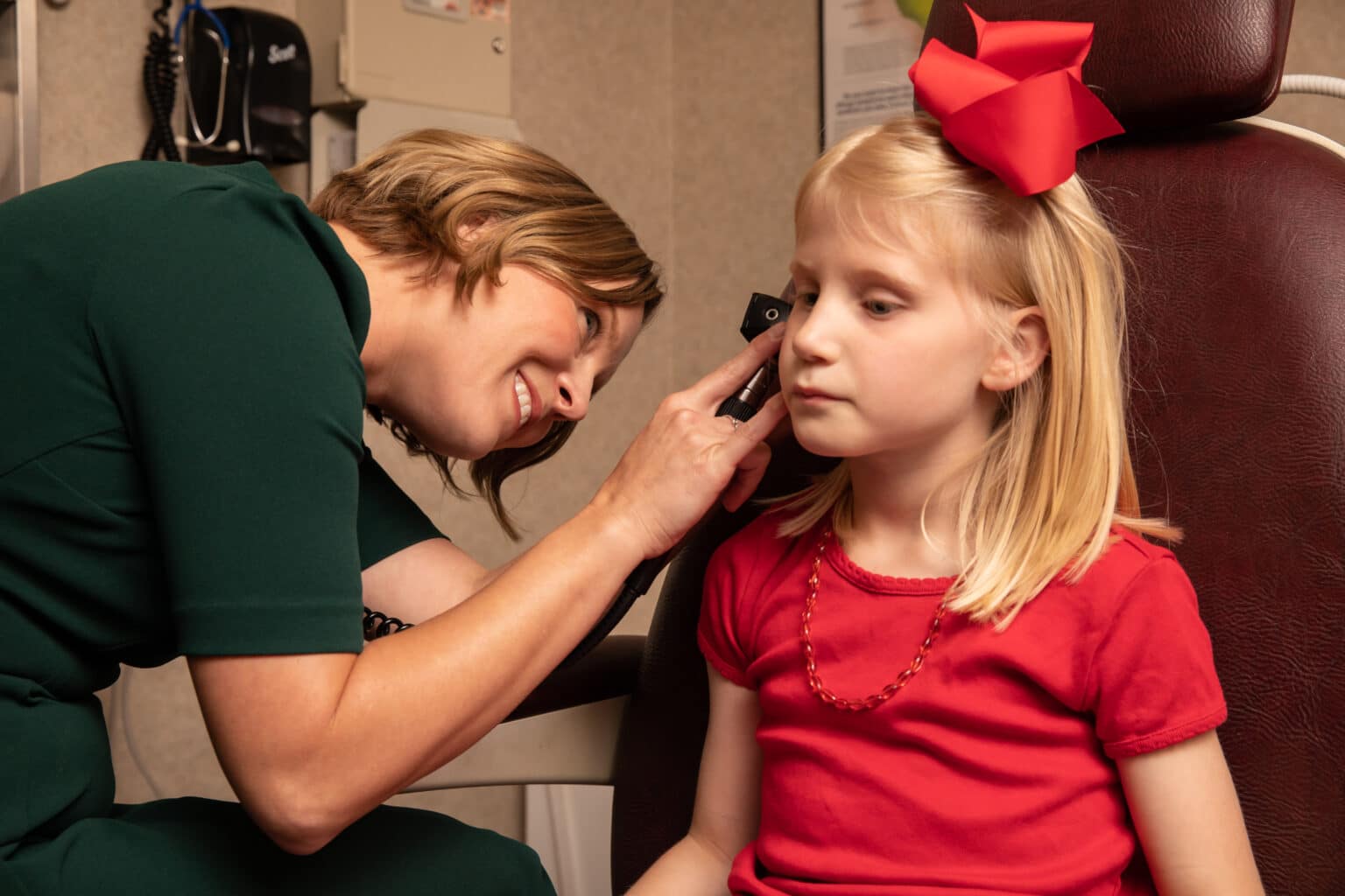 ENT examining a pediatric patients ear for signs of infection