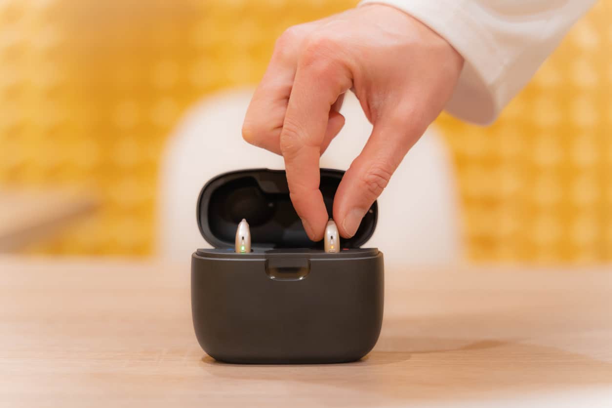 Person putting hearing aids in a case.