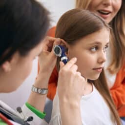 Young girl having her ear examined
