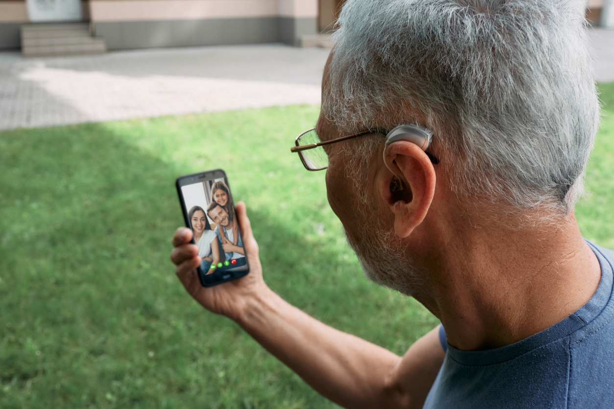 Man with hearing aids video chats with family