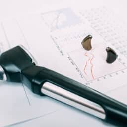 Hearing exam result - audiogram and hearing aids on the table