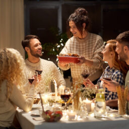 Happy friends having dinner at home